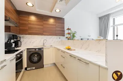 a kitchen with white counters and a dishwasher at Vogue Business Bay - Bay Square close to Downtown Dubai Mall and Burj Khalifa, One Bedroom Apartment with Balcony and City view in Dubai