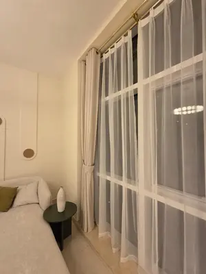 a bedroom with a large window with white curtains at Duja Tower 4404 in Dubai