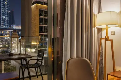 a room with a balcony with a table and a lamp at Elite Escape - Stylish Getaway in Azizi Riviera 43 in Dubai