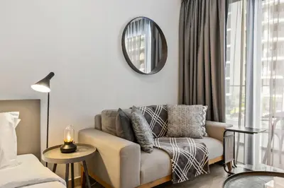 a living room with a couch and a mirror at Elite Escape - Stylish Getaway in Azizi Riviera 43 in Dubai