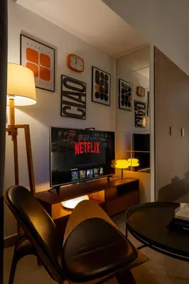 a living room with a television and a chair at Elite Escape - Stylish Getaway in Azizi Riviera 43 in Dubai
