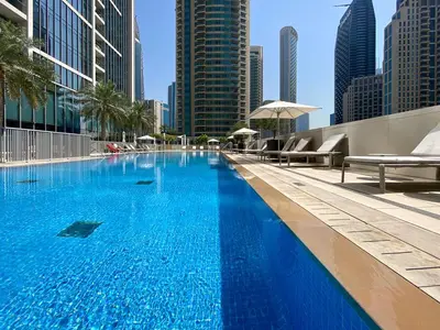 a large swimming pool in a city with tall buildings at Forte Tower 2, Downtown - 2 Bedroom - Allsopp & Allsopp in Dubai