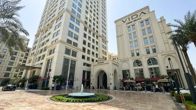a building with a fountain in front of two tall buildings at 833keys - 1BR - Lagoon Access - Vida Creek Beach - Creek Harbour - Dubai in Dubai