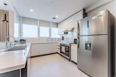 a kitchen with a stainless steel refrigerator and appliances at Duplex Apartment Next to Zabeel Park, Steps from the Metro Station, and Minutes to Downtown Dubai, Al Kifaf 1 Residences East, Bur Dubai, by Deluxe Holiday Homes in Dubai