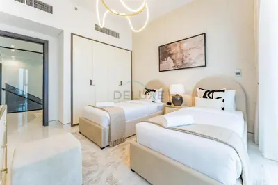 a bedroom with two beds and a chandelier at Duplex Apartment Next to Zabeel Park, Steps from the Metro Station, and Minutes to Downtown Dubai, Al Kifaf 1 Residences East, Bur Dubai, by Deluxe Holiday Homes in Dubai