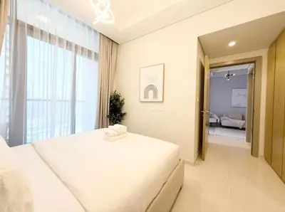 a bedroom with a white bed and a large window at Exquisite 2BR With Balcony in Business bay in Dubai