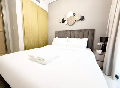 a bedroom with a white bed and a clock on the wall at Exquisite 2BR With Balcony in Business bay in Dubai