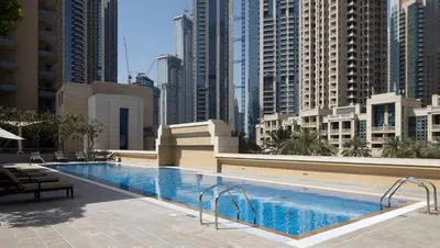 a large swimming pool in a city with tall buildings at Silkhaus Chic Studio in Downtown at Claren Tower in Dubai