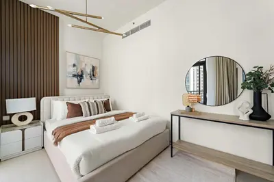 a bedroom with a large bed and a mirror at Silkhaus Chic Studio in Downtown at Claren Tower in Dubai