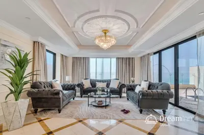 a large living room with couches and a chandelier at Dream Inn - Timeless Arabic-Inspired Penthouse with Private Pool and Sweeping Ain Dubai Views in Dubai