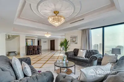 a living room with couches and a chandelier at Dream Inn - Timeless Arabic-Inspired Penthouse with Private Pool and Sweeping Ain Dubai Views in Dubai