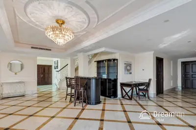a living room with a table and a chandelier at Dream Inn - Timeless Arabic-Inspired Penthouse with Private Pool and Sweeping Ain Dubai Views in Dubai