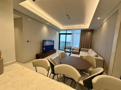 a living room with a table and chairs and a couch at Luxury 2BR - Nobles Tower - Business Bay in Dubai