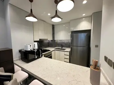 a kitchen with a refrigerator and a counter top at Luxury 2BR - Nobles Tower - Business Bay in Dubai