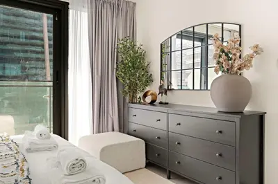 a bedroom with a dresser and a mirror at Silkhaus Modern 2BR in Merano Tower in Business Bay in Dubai