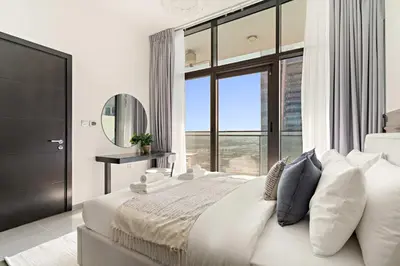 a bedroom with a large bed with a large window at Silkhaus Modern 2BR in Merano Tower in Business Bay in Dubai