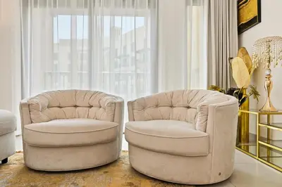 two white chairs in a living room with a window at Luxury 1BD Stay in Lamtara 2, Near Jumeirah Burj in Dubai