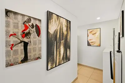 three paintings on a wall in a room at Luxury 1BD Stay in Lamtara 2, Near Jumeirah Burj in Dubai