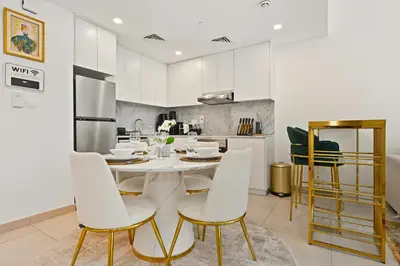 a kitchen with a table and chairs in a room at Luxury 1BD Stay in Lamtara 2, Near Jumeirah Burj in Dubai