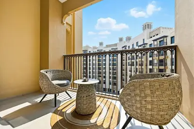 a balcony with two chairs and a table with a view at Luxury 1BD Stay in Lamtara 2, Near Jumeirah Burj in Dubai