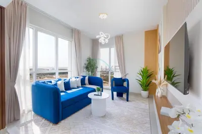 a blue couch in a living room with windows at Balcony Offering Captivating Lake Views 1BR, Just a Hop from the Golf Course, Lakeside B, Dubai Production City by Deluxe Holiday Homes in Dubai