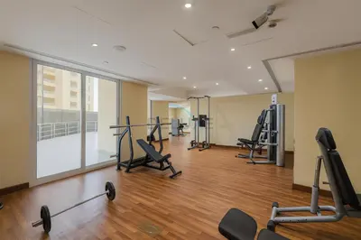 a gym with treadmills and exercise equipment in a building at Balcony Offering Captivating Lake Views 1BR, Just a Hop from the Golf Course, Lakeside B, Dubai Production City by Deluxe Holiday Homes in Dubai
