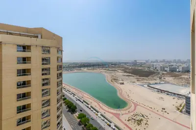 a view of a beach from a building at Balcony Offering Captivating Lake Views 1BR, Just a Hop from the Golf Course, Lakeside B, Dubai Production City by Deluxe Holiday Homes in Dubai