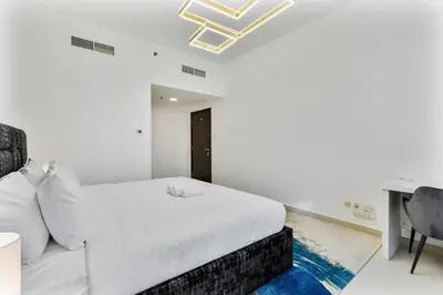 a white bedroom with a bed and a desk at Chic 4-Sleeper near JBR Beach & Dubai Marina Mall in Dubai