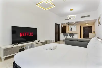 a living room with a bed and a television at Chic 4-Sleeper near JBR Beach & Dubai Marina Mall in Dubai