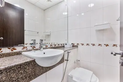 a white bathroom with a sink and a toilet at Chic 4-Sleeper near JBR Beach & Dubai Marina Mall in Dubai