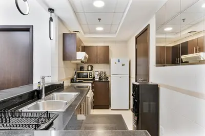 a kitchen with a sink and a refrigerator at Chic 4-Sleeper near JBR Beach & Dubai Marina Mall in Dubai