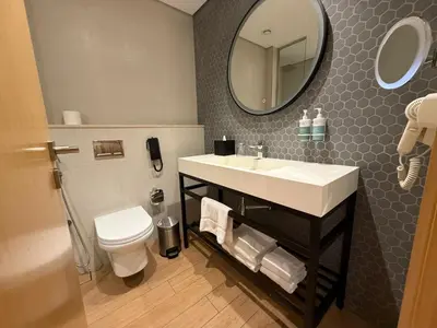 a bathroom with a sink and a toilet and a mirror at Luxery Hotel Apartment l Novotel Residence l JVT in Dubai