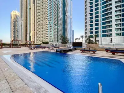 a large swimming pool in a city with tall buildings at Premium 1BR on High Floor with Stunning Sea View and Balcony in Dubai