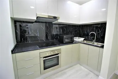 a kitchen with white cabinets and a sink at Premium 1BR on High Floor with Stunning Sea View and Balcony in Dubai