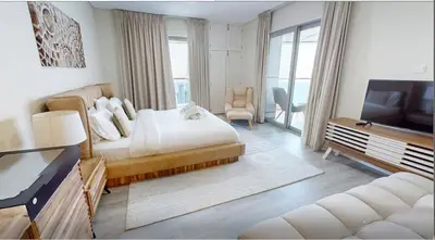 a bedroom with a bed and a tv and a couch at Premium 1BR on High Floor with Stunning Sea View and Balcony in Dubai