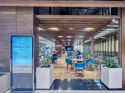 a restaurant with blue chairs and tables in a building at FIRST CLASS 2BR Elegant Duplex Haven in Dubai