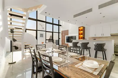 a dining room and kitchen with a table and chairs at FIRST CLASS 2BR Elegant Duplex Haven in Dubai