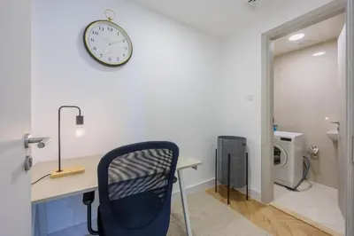 a office with a desk and a clock on a wall at Waterfront Serenity in Dubai Marina in Dubai