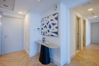 a hallway with a table and a painting on the wall at Waterfront Serenity in Dubai Marina in Dubai
