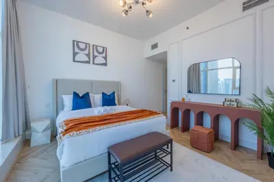 a bedroom with a large bed with blue pillows at Waterfront Serenity in Dubai Marina in Dubai