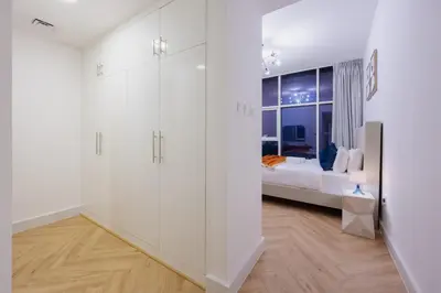 a white bedroom with a bed and a window at Waterfront Serenity in Dubai Marina in Dubai