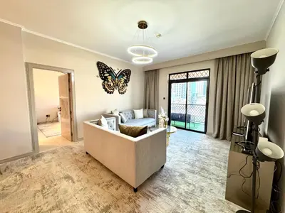 a living room with a couch and a butterfly on the wall at Burj Khalifa View 2 Bed Luxury Apartment in Dubai