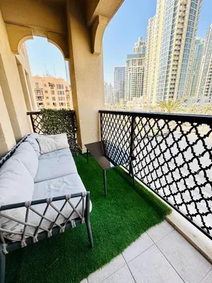 a balcony with a bed and green grass at Burj Khalifa View 2 Bed Luxury Apartment in Dubai