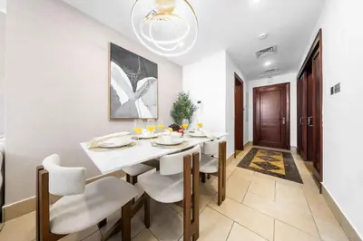 a dining room with a white table and chairs at Full Burj View - Souk vibe one-bedroom apartment in Dubai