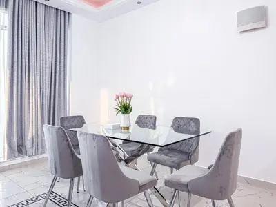 a dining room with a glass table and chairs at Opal Tower Condos - Dubai Marina in Dubai