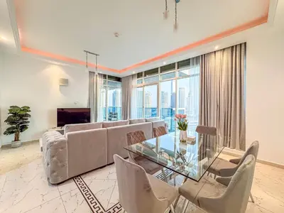 a living room with a glass table and chairs at Opal Tower Condos - Dubai Marina in Dubai