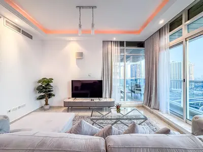 a living room with a couch and a tv at Opal Tower Condos - Dubai Marina in Dubai