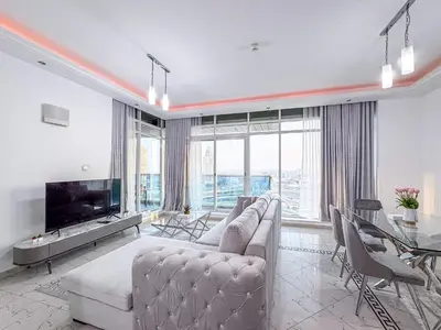 a living room with a couch and a tv and a table at Opal Tower Condos - Dubai Marina in Dubai