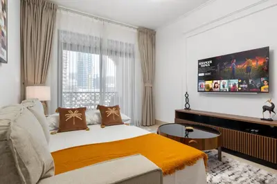 a bedroom with a bed and a tv on the wall at Sleep 5 Near Dubai Mall in Dubai
