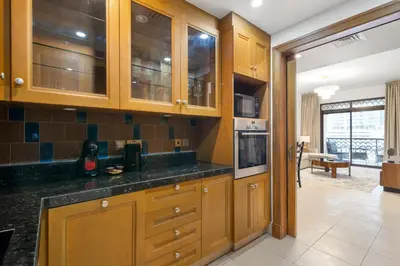 a kitchen with wooden cabinets and black counter tops at Sleep 5 Near Dubai Mall in Dubai